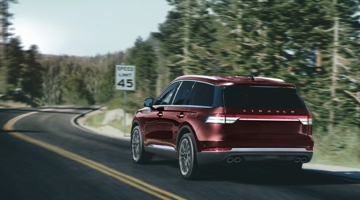A 2024 Lincoln Aviator® SUV is being driven on a winding mountain road | Caruso Lincoln in Long Beach CA